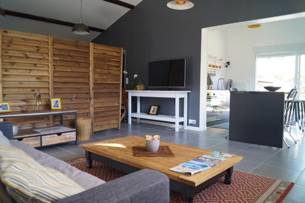 uma sala de estar com um sofá e uma mesa em Gîte La Malonière em Saint-Martin-du-Bois