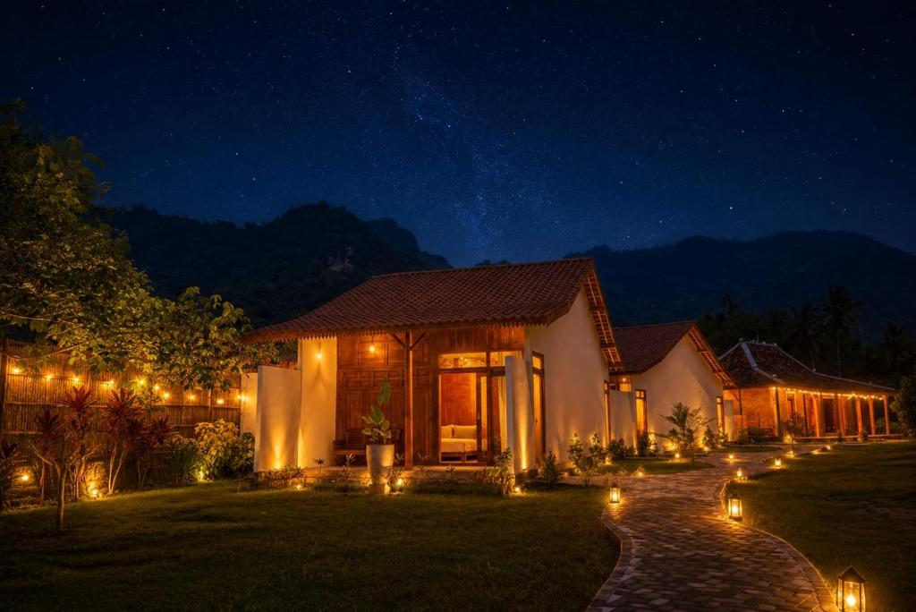 a house lit up at night with lights at Villa Kebun Pala in Borobudur