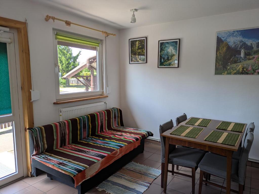 a living room with a couch and a table at Biały domek przy Hajnówce in Dubiny