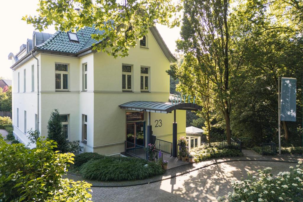 a yellow house with a black gate at Hotel Das Lola in Essen