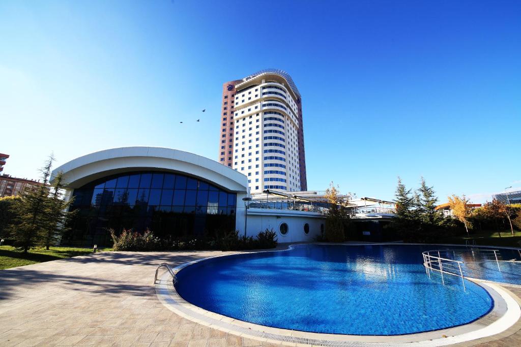 a large swimming pool in front of a building at Dedeman Konya Hotel Convention Center in Konya