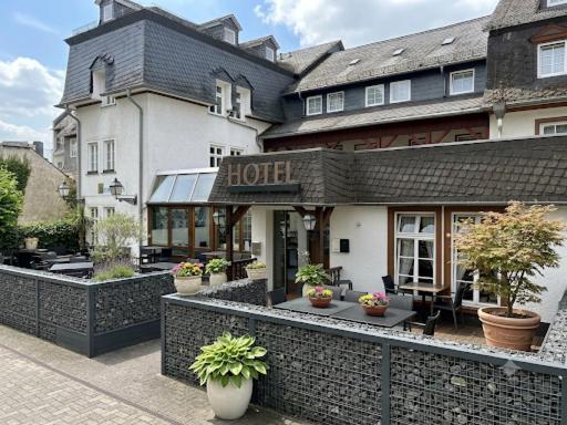 a hotel with potted plants in front of it at Hotel Bürgerhof Wetzlar in Wetzlar