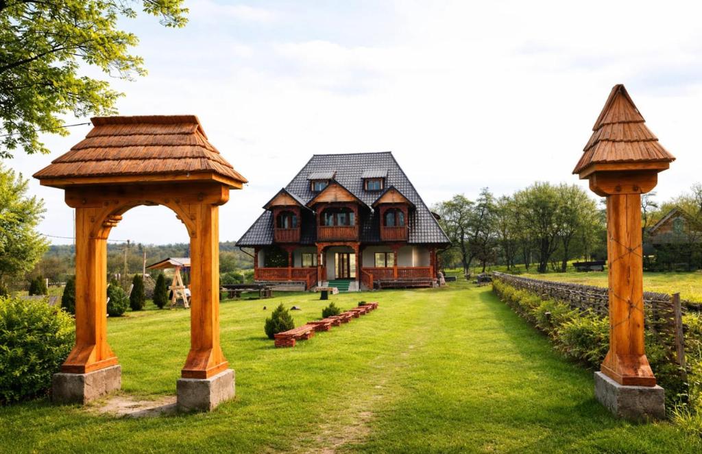 a house with two gazebos in the yard at Casa Moroseneasca Breb in Breb