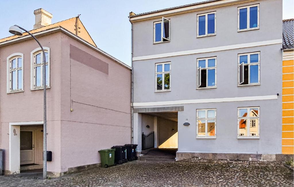 a white house with a garage next to a building at 3 Bedroom Pet Friendly Apartment In Faaborg in Faaborg