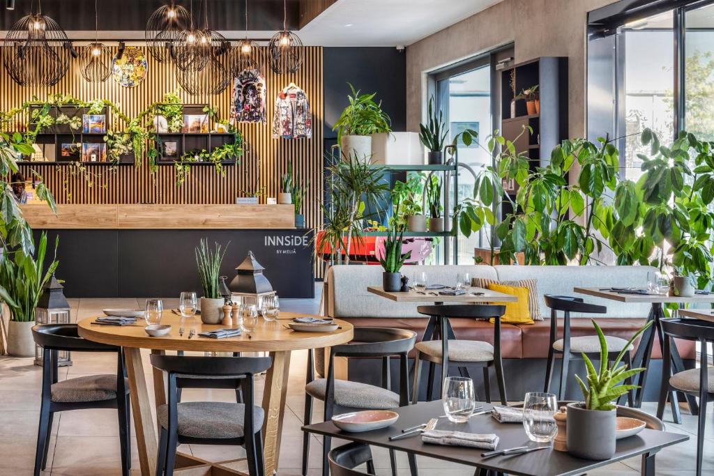 a restaurant with tables and chairs and plants at INNSiDE by Meliá Luxembourg in Luxembourg