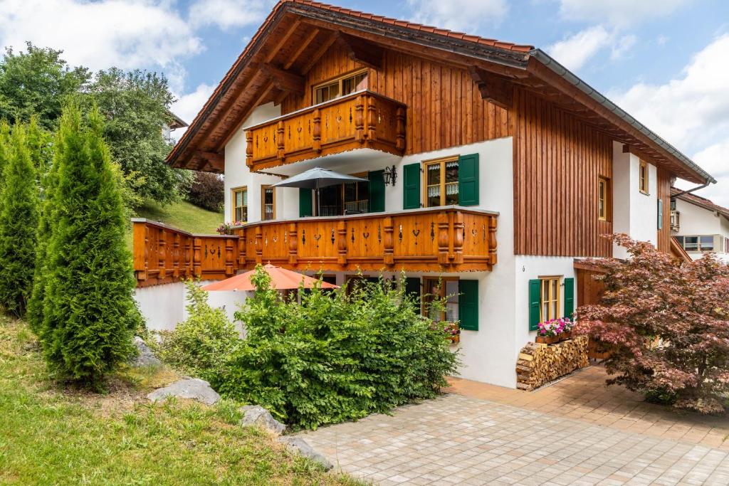 a house with wooden balconies and a courtyard at Haus Christian und Hanni in Bad Kohlgrub