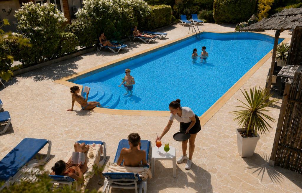 a group of people playing in a swimming pool at Les Jardins de Bormes, hôtel de charme et détente, espace bien-être avec sauna & jacuzzi in Bormes-les-Mimosas