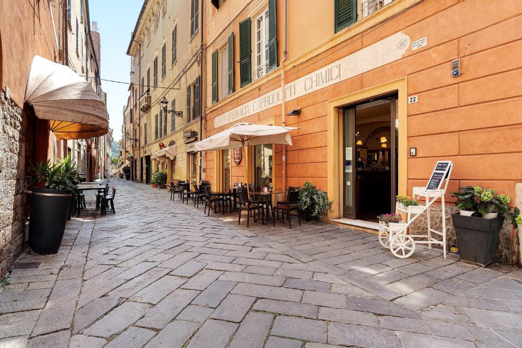 an empty street with tables and chairs in front of buildings at Aura Suites in Albenga