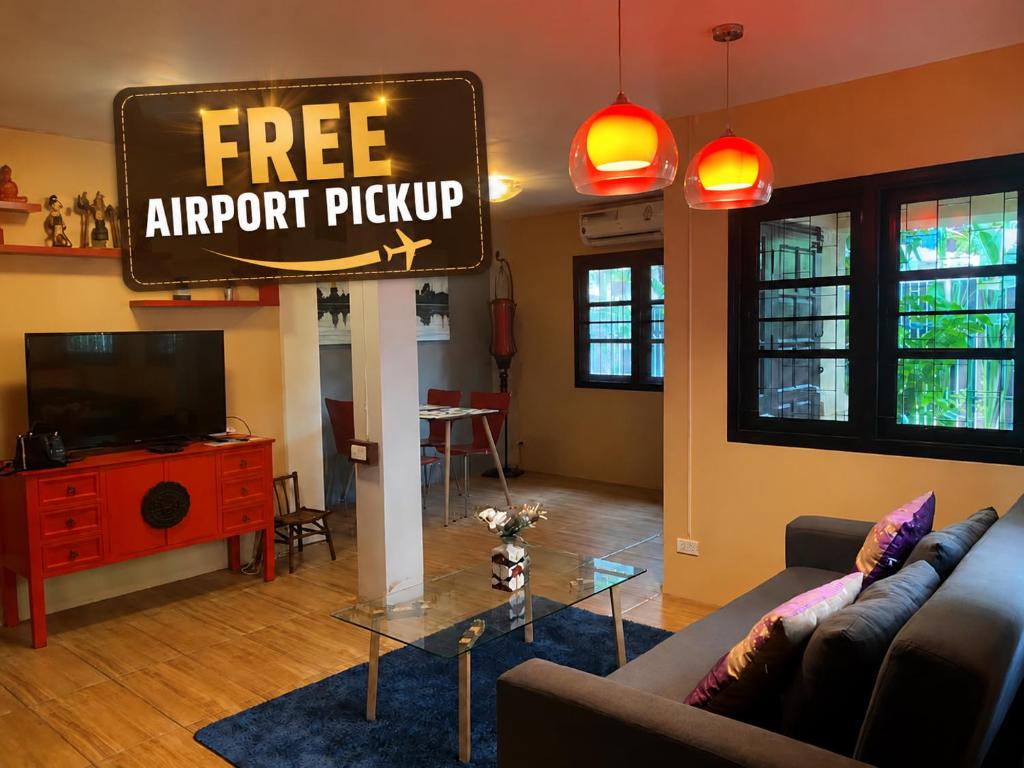 a living room with a free airport priority sign at Old City Hidden Gem Villa in Chiang Mai