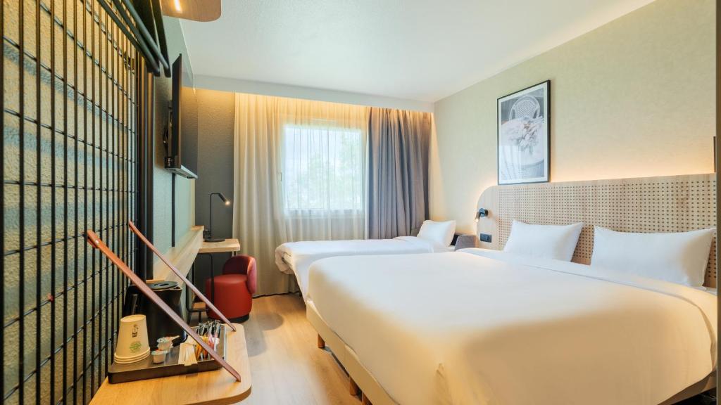 ein Hotelzimmer mit zwei Betten und einem Fenster in der Unterkunft TULIP Hotels & Residences - Marne-la-Vallee Torcy in Torcy