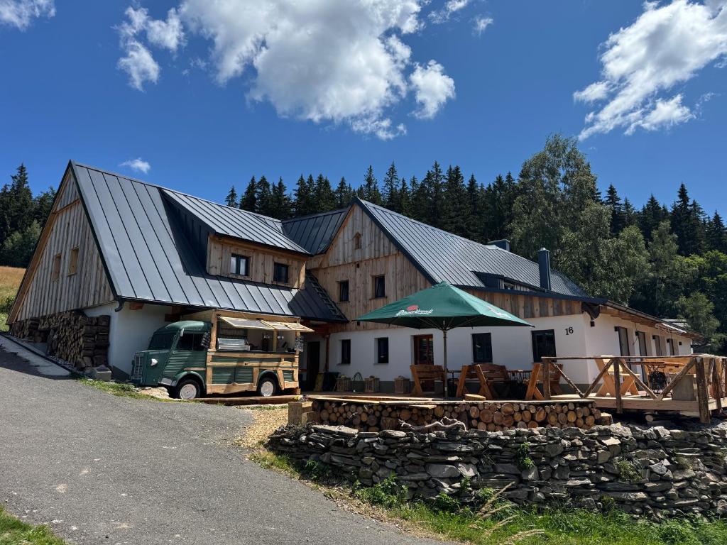 a barn with a truck parked in front of it at Chata Borůvka in Pec pod Sněžkou