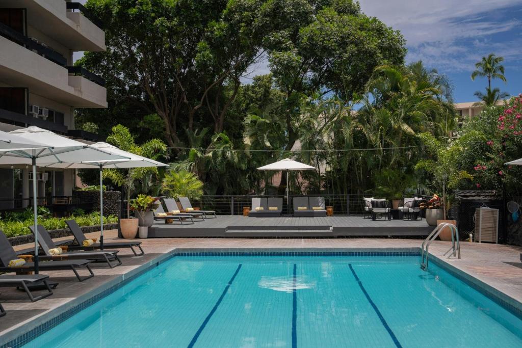 a pool at a hotel with chairs and umbrellas at PACIFIC 19 Kona in Kailua-Kona