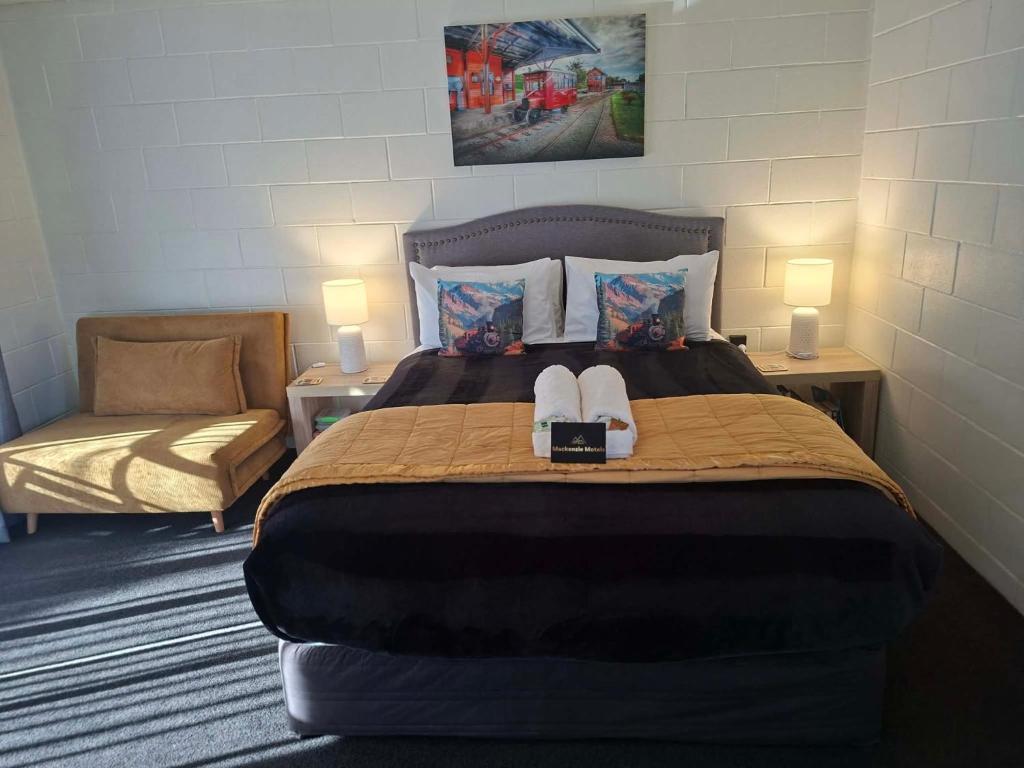 a bedroom with a bed with two shoes on it at Mackenzie Motels in Fairlie