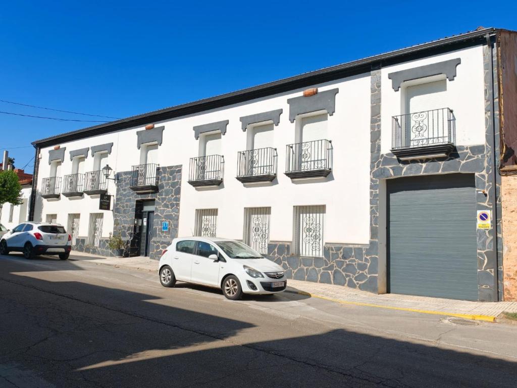 a white car parked in front of a building at Apartamentos La Bodega in La Zarza