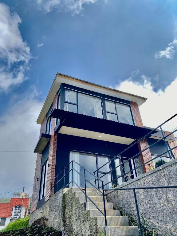 a brick house with glass windows and stairs at Oemah Ntuy Full view in Diyeng
