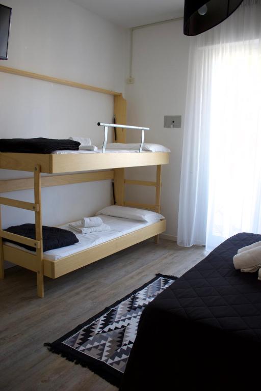 a bedroom with two bunk beds and a window at CASA MAJOR Appartamenti in Cervia