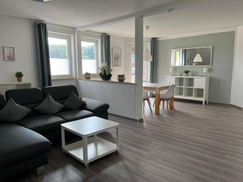 a living room with a couch and a table at Ferienwohnung Schöpf - Fränkische Schweiz in Obertrubach