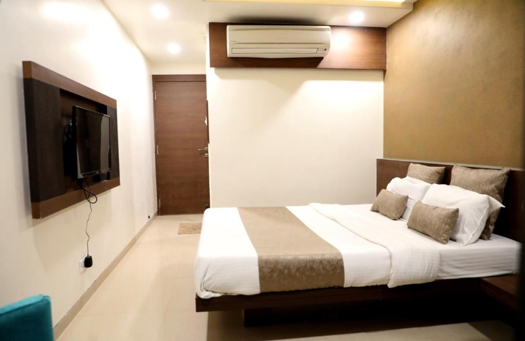 1 dormitorio con 1 cama y TV de pantalla plana en Adarsh Palace Hotel, en Bhopal