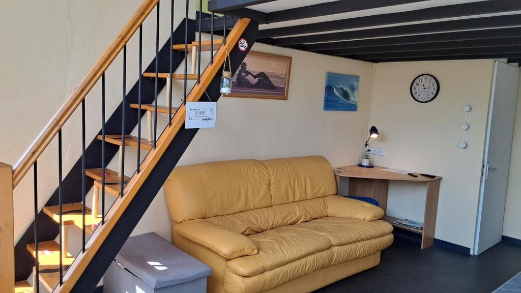 a living room with a couch and a staircase at Le Relais des Ducs in Duras