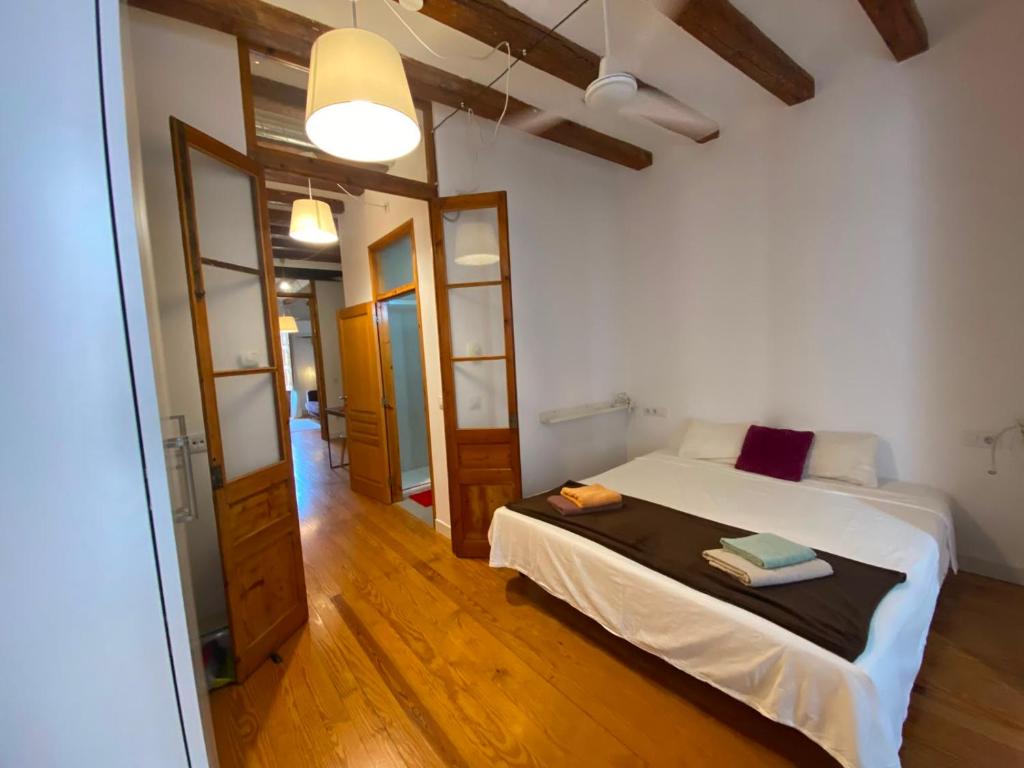 a bedroom with a bed in a room with wooden floors at Calle Villarroel Barcelona 3-2 in Barcelona