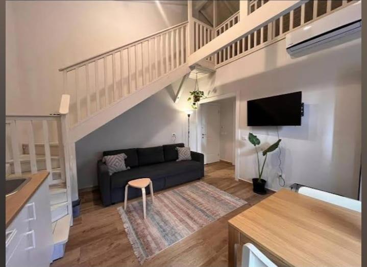 a living room with a couch and a staircase at נענע in Keshet