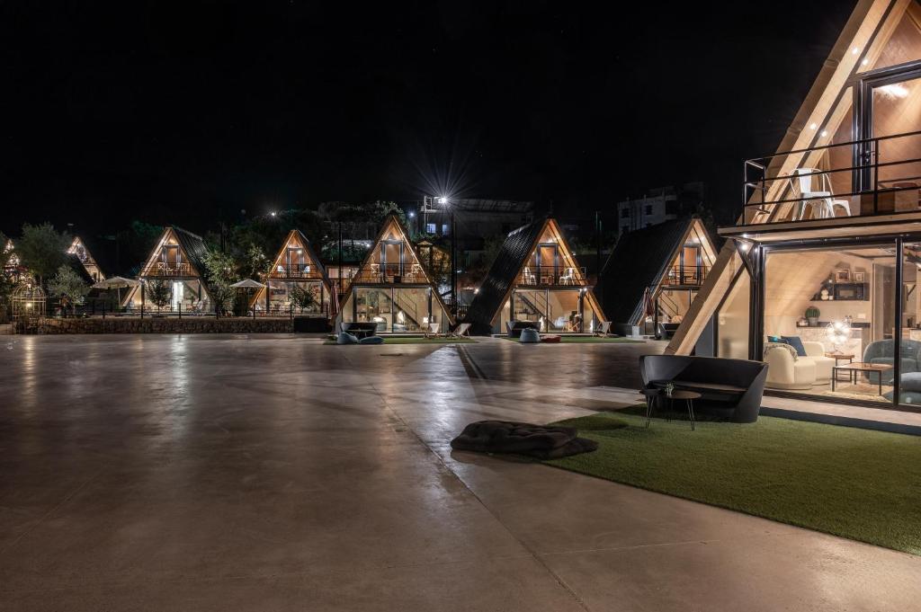 a room with a couch on the ground in front of a building at Maison Jwar - Luxury A-Shape Cabins - A Unique Summer Getaway in Ḩārat at Taḩtā
