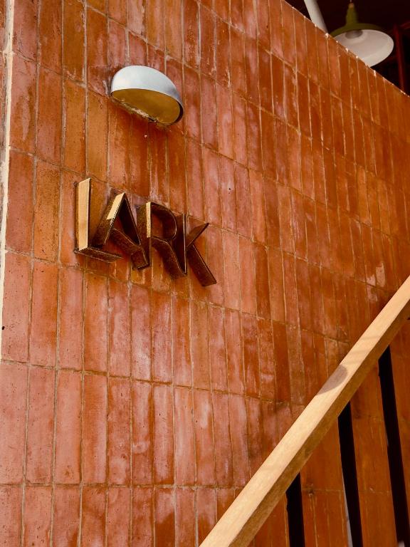 a sign on the side of a brick wall with the wordaan at The Lark Inn & Kitchen in San Juan