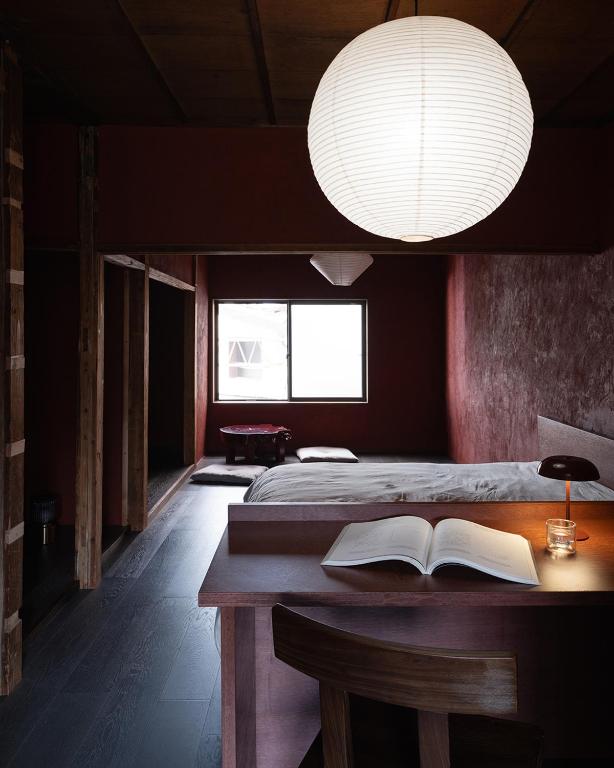 a bedroom with a bed and a table with a book at 刷々 sassa in Osaka