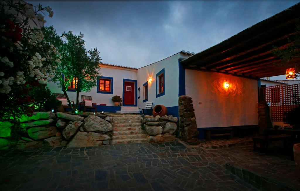 a house with a stone wall in front of it at Casa Palheiro, Aldeia da Pedralva in Vila do Bispo