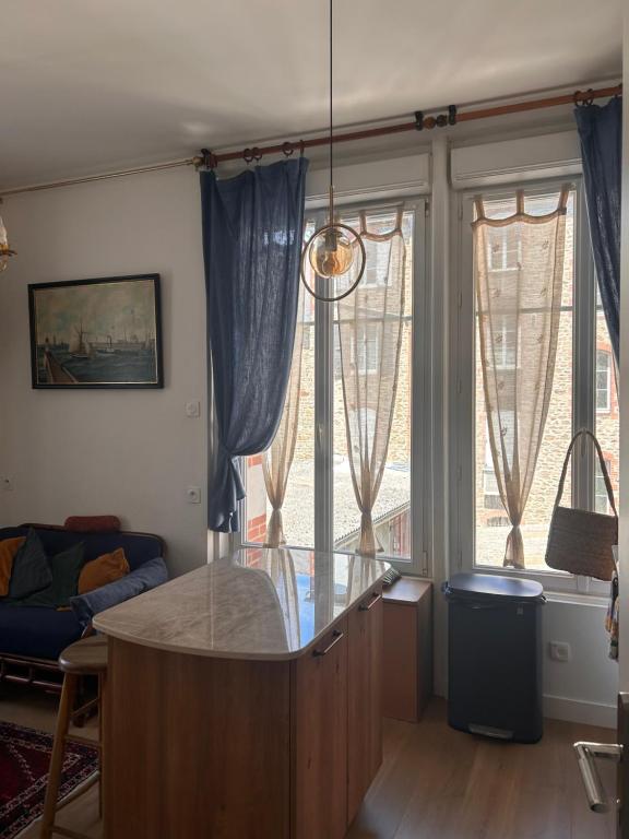 a living room with a table and some windows at studio 25 in Dinard
