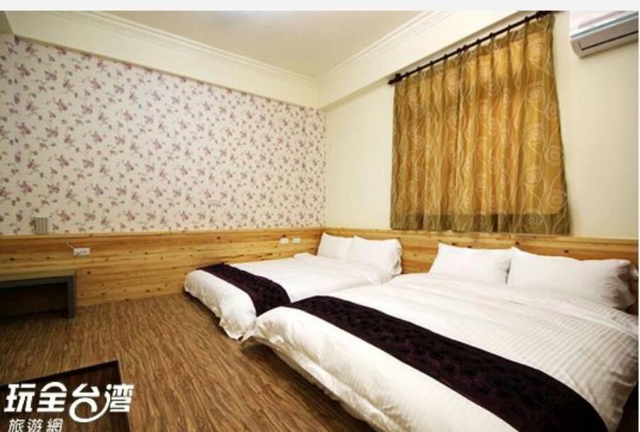 金寧鄉的住宿－鳳鳴民宿，一间卧室设有两张床和窗户。
