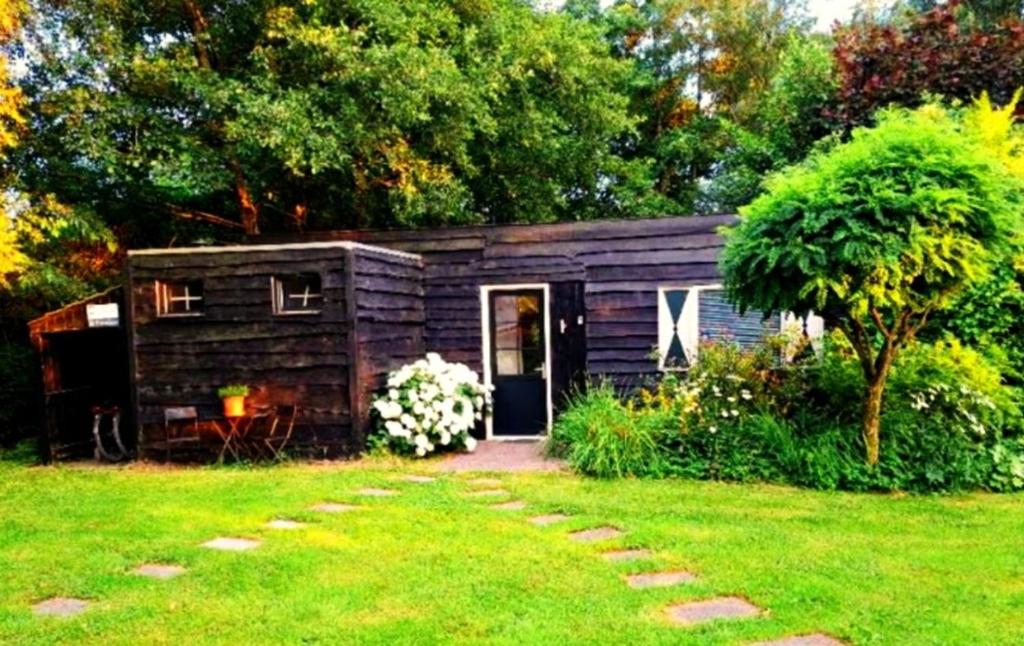 a small cabin with a door in a yard at De Vuurplaats in Drachten