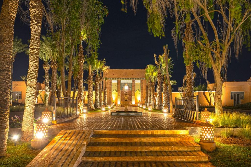 a courtyard with palm trees and lights at night at SOL by Meliá Oasis Marrakech - All Inclusive in Marrakesh