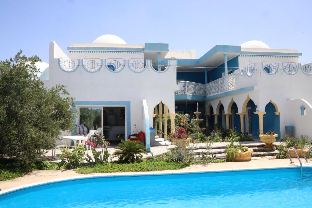 a house with a swimming pool in front of it at Dar Mimouna Djerba in Tianest