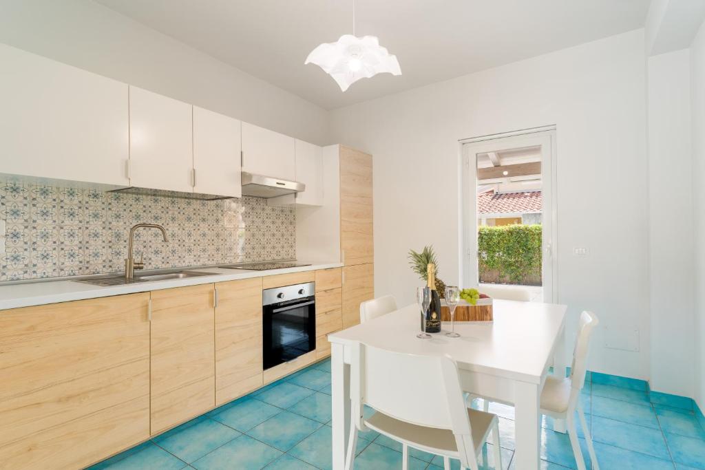 a kitchen with a white table and a dining room at CalaDune Villas in Pizzo