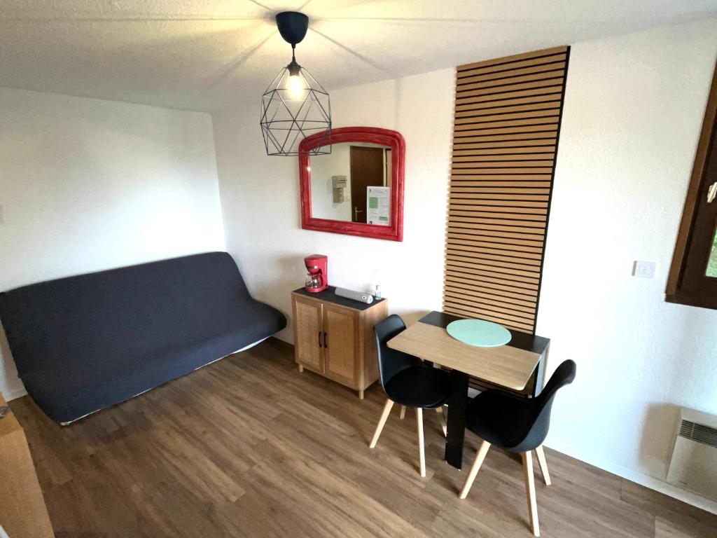 a small room with a table and a blue couch at EcrAin Montagnard in Lélex