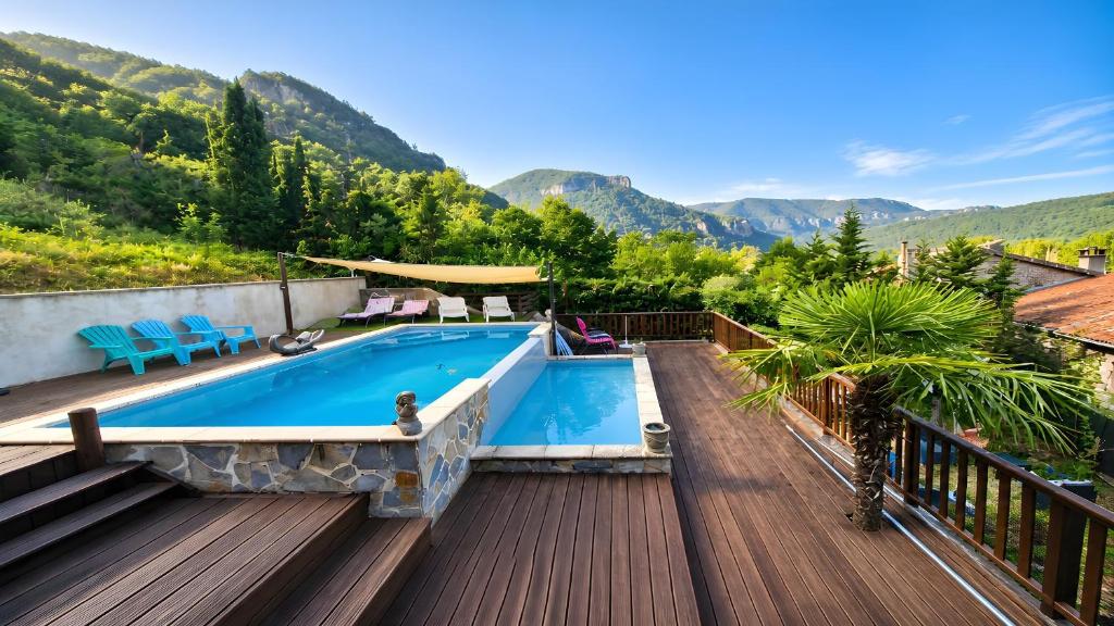 a pool on a deck with mountains in the background at LES GARGOUILLES - Piscine à Débordement Avec Vue Exceptionnelle - Gorges du Tarn - Millau in Boyne