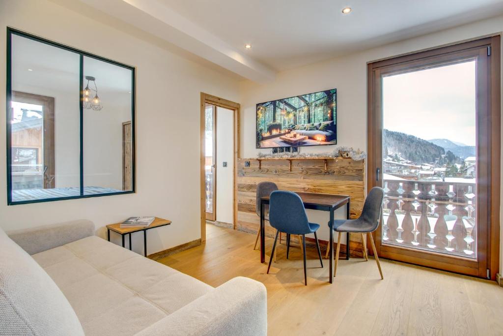 a living room with a couch and a table with chairs at Edelweiss Lodge in Morzine