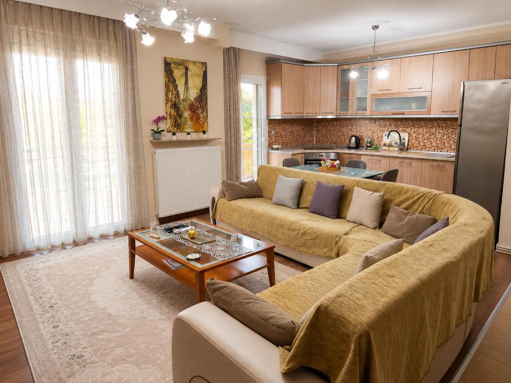 a living room with two couches and a kitchen at ANATOLI Waterfalls Retreat in Edessa