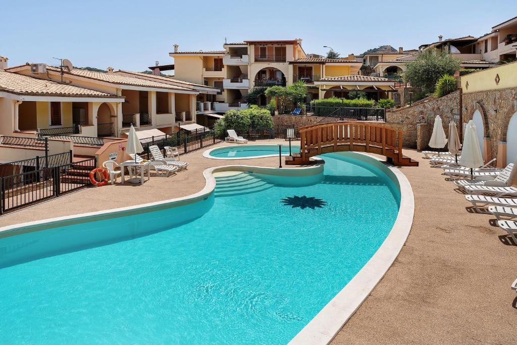 a large swimming pool with chairs in a resort at I girasoli in Villasimius