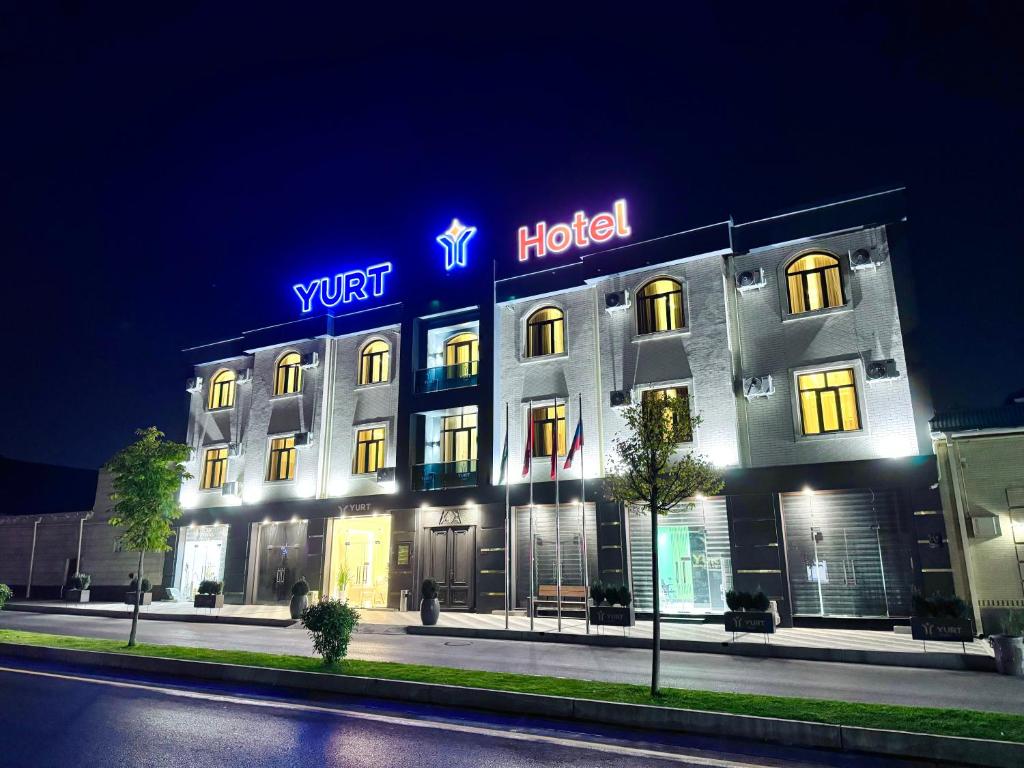 a hotel with a lit up sign on top of it at YURT Boutique Hotel in Samarkand