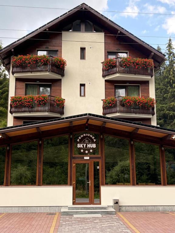 a building with flower boxes on the front of it at PENSIUNEA SKY HUB in Arieşeni