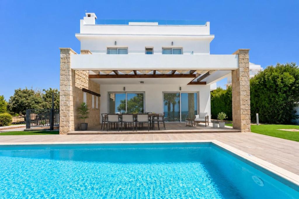 a villa with a swimming pool in front of a house at Villa Celestia in Neo Chorio