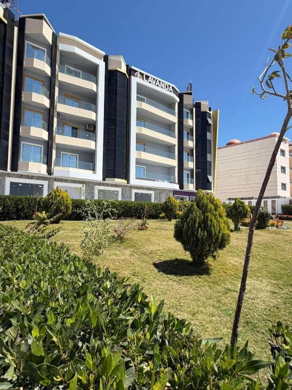 a large building with a park in front of it at Lavanda Beach Resort in Abū Rudays