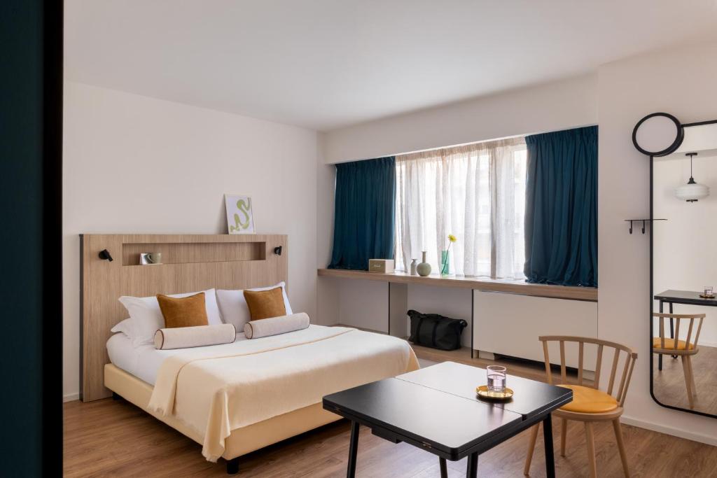 a hotel room with a bed and a table at Aparthotel Colombo Roma in Rome
