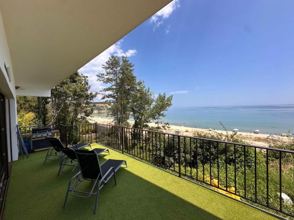 a balcony with chairs and a view of the beach at Бунгала " SEA VILLAGE DAR " in Kamchia