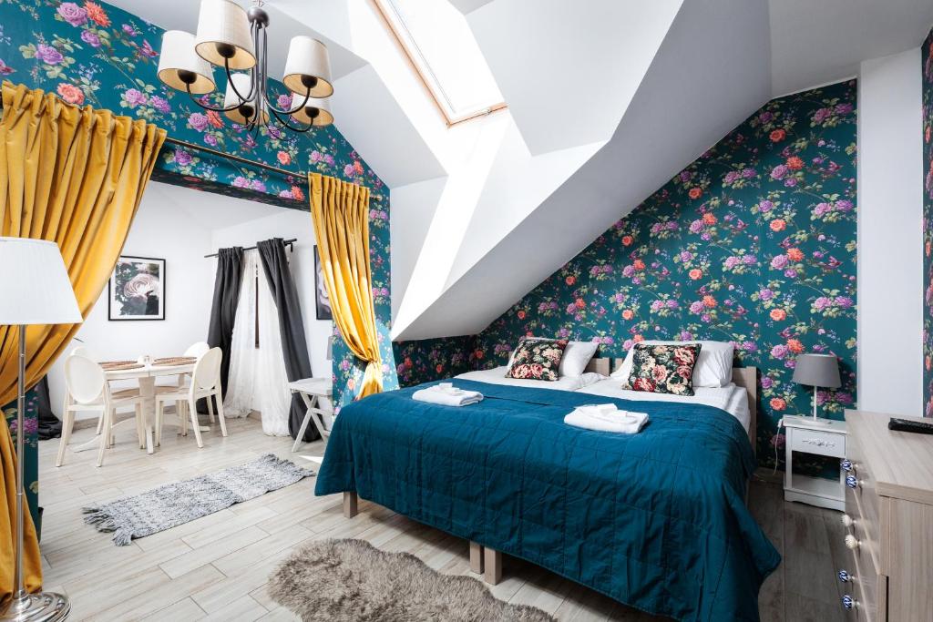 a bedroom with a blue bed with floral wallpaper at Pokoje w Starej Karczmie - Free Parking - by Upstairs in Liszki