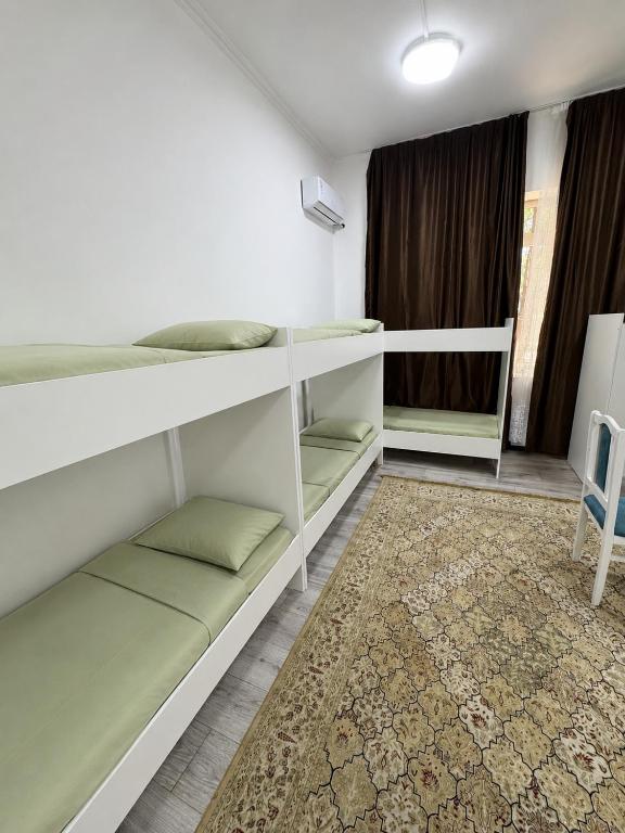 a room with two bunk beds and a rug at Global Hostel 3 in Almaty