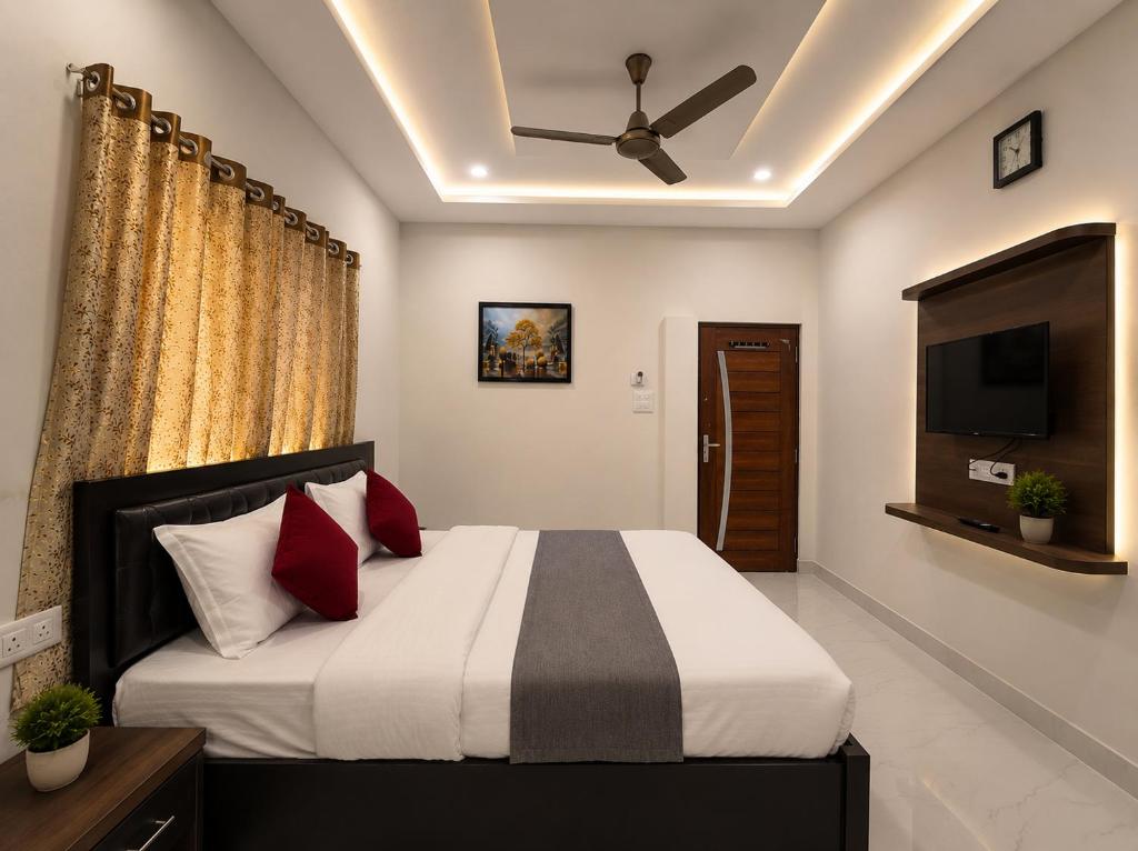 a bedroom with a bed with a ceiling fan at Landmark Hotel in Jodhpur