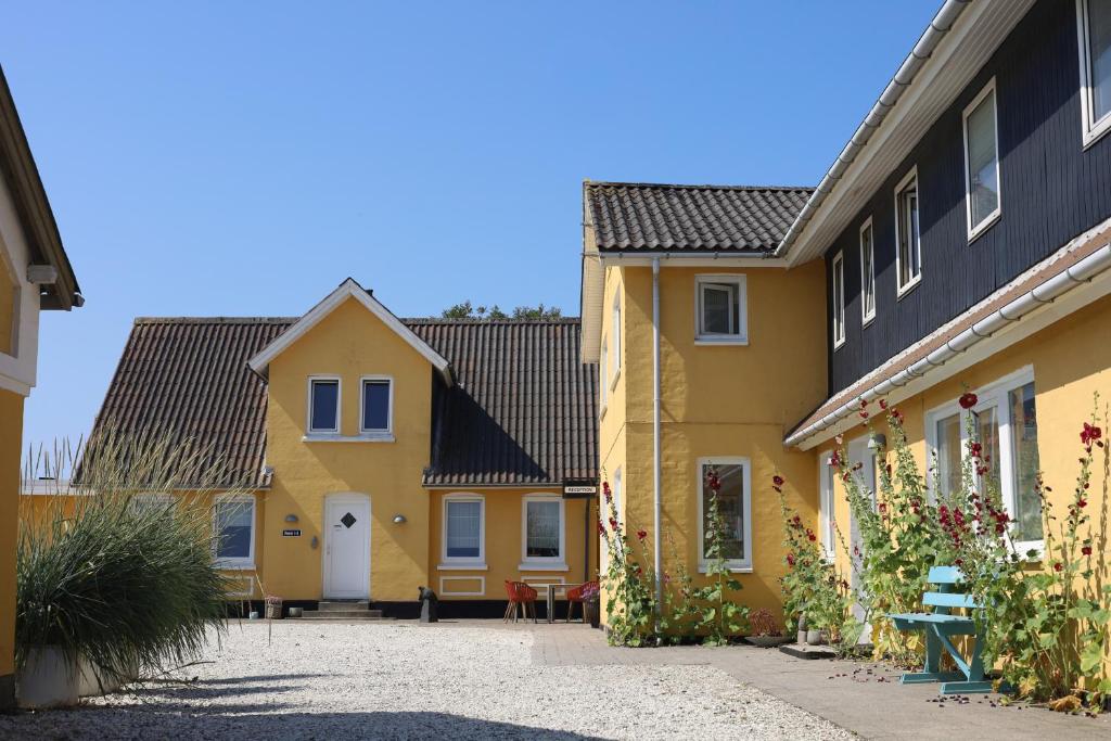 a row of yellow houses with black roofs at Lønstrup Strandhotel in Lønstrup